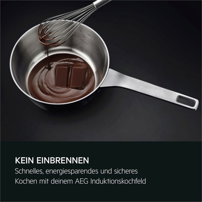 Ein Schneebesen rührt geschmolzene Schokolade in einem Topf; zwei Schokoladenstücke liegen darin.